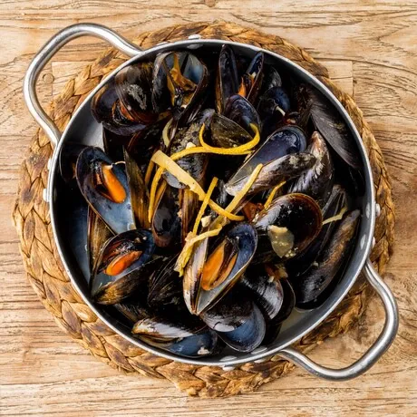 Moules avec agrumes, laurier, ail et oignon